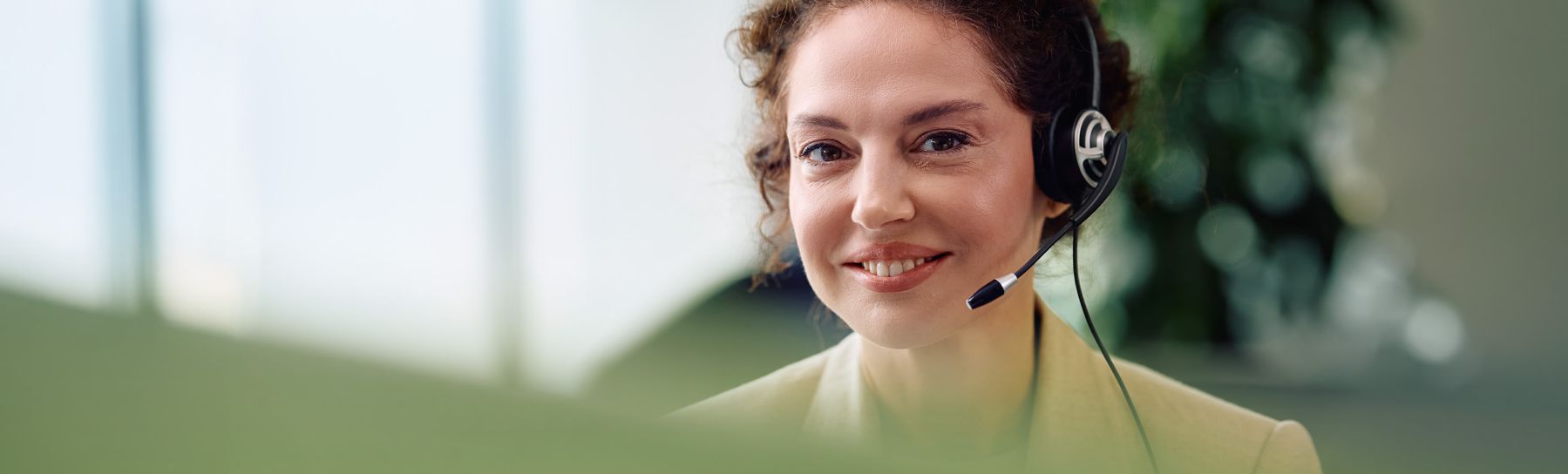Lächelnder Callcenter-Agent im Büro, der in die Kamera schaut.