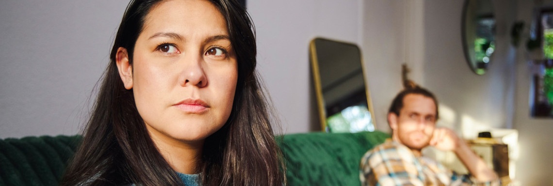 Pärchen sitzt traurig voneinander abgewandt auf dem Sofa