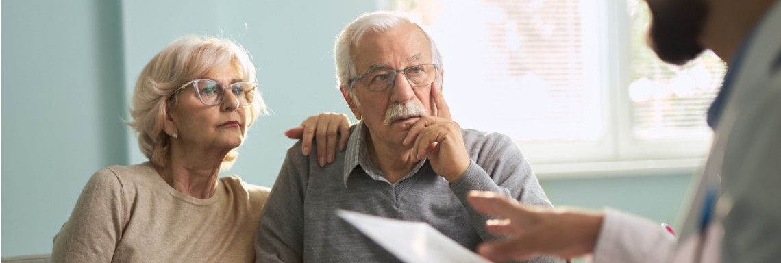 Älteres Paar auf Sofa Gespräch mit Mann mit Vertrag