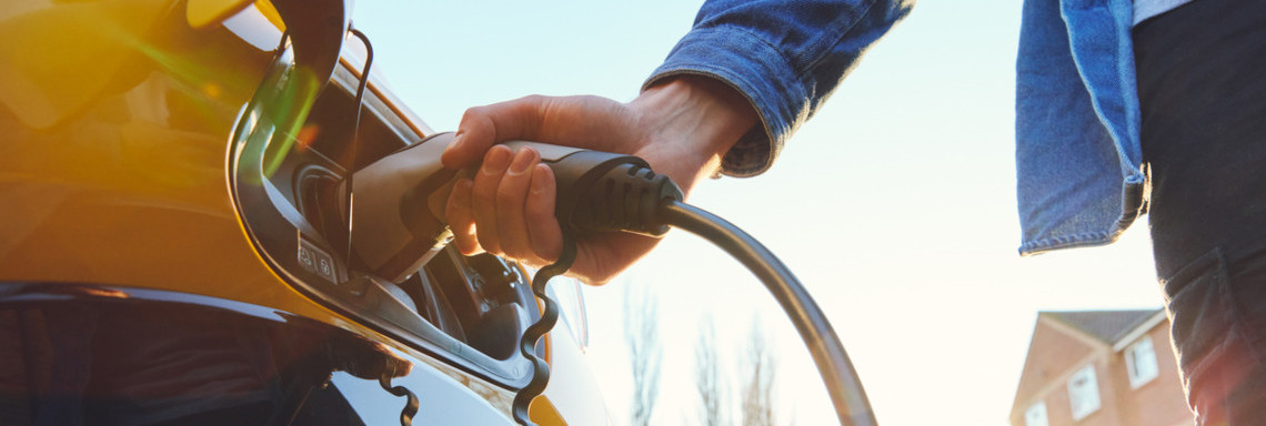 Person lädt Elektroauto auf