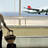 Flug verpasst: Frau mit Handgepäck sieht Flugzeug starten