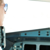 Pilot mit Sonnenbrille im Cockpit