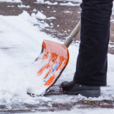 Ein Mann schippt Schnee: Kann die Räumpflicht bei Schnee vor 7 Uhr gelten?