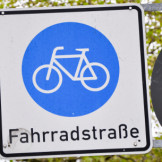 Fahrradstraße: Welche Regeln gelten dort? Ein blaues Verkehrsschild auf den ein weißes Fahrrad und das Wort 