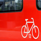 Fahrradtransport: Das ist auf Reisen erlaubt. Ein roter Wagon auf dem ein Fahrrad-Piktogram abgebildet ist.