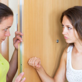 Hausfrieden gestört: Fristlose Kündigung ist rechtens. Zwei junge Frauen stehen sich zwischen Tür und Angel gegenüber. Die eine hebt ihre Faust.