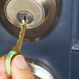 Schlüssel nachmachen: Das sollten Mieter wissen. Jemand steckt einen Haustürschlüssel in ein Schloss.