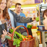 500-Euro-Schein wechseln: Dürfen Händler ihn ablehnen? Eine junge Frau steht an einer Supermarktkasse und schaut in ihr Portemonnaie.