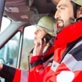 Mindestlohn gilt auch während der Bereitschaft. Ein Feuerwehrmann und eine Feuerwehrfrau sitzen in einem Feuerwehrauto.