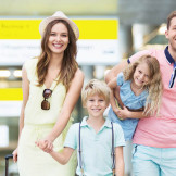 Familie mit Reisegepäck geht glücklich über den Flughafen 