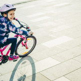 Kind fährt Fahrrad und lacht