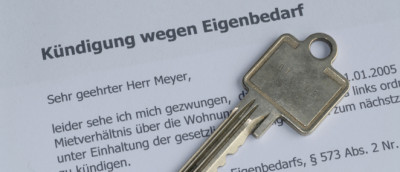 Brief mit Titel Kündigung wegen Eigenbedarf, Haustürschlüssel darauf Brief mit Titel Kündigung wegen Eigenbedarf, Haustürschlüssel darauf