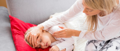 Mutter fühlt ihrem fieberkranken Kind die Stirn Mutter fühlt ihrem fieberkranken Kind die Stirn
