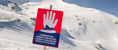 Lawinengefahr: Ist ein Reiserücktritt möglich? Ein Lawinen-Warnschild vor einer bergigen Schneelandschaft. Lawinengefahr: Ist ein Reiserücktritt möglich? Ein Lawinen-Warnschild vor einer bergigen Schneelandschaft.