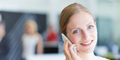 junge Frau telefoniert mit Handy am Ohr