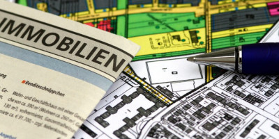 Immobilienanzeige muss Angaben zum Energieausweis enthalten. Auf mehreren Grundrissen liegt eine Immobilenanzeige.