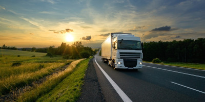 LKW auf Landstraße im Sonnenuntergang