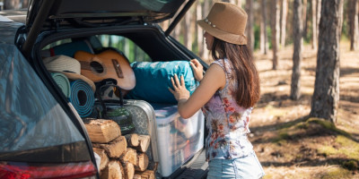 Junge Frau packt Kofferraum zu voll