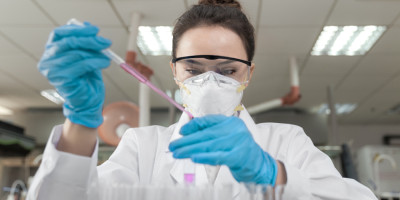 Frau mit Atemschutzmaske macht Test mit Pipette Frau mit Atemschutzmaske macht Test mit Pipette