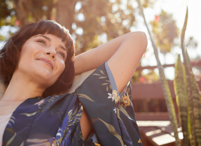 Frau liegt an einem sonnigen Nachmittag im Liegestuhl und lächelt Frau liegt an einem sonnigen Nachmittag im Liegestuhl und lächelt
