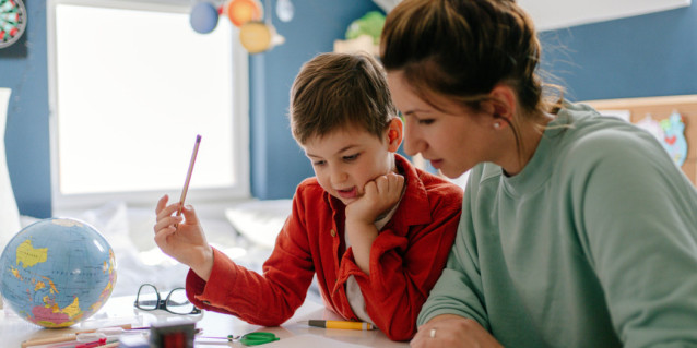 Mutter und Sohn machen in Kinderzimmer Schulaufgaben