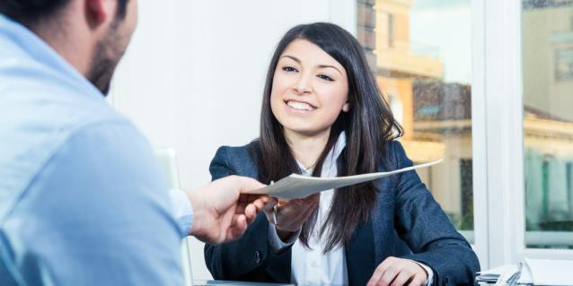 Lächelnde Frau gibt Mann in Büro ein Dokument