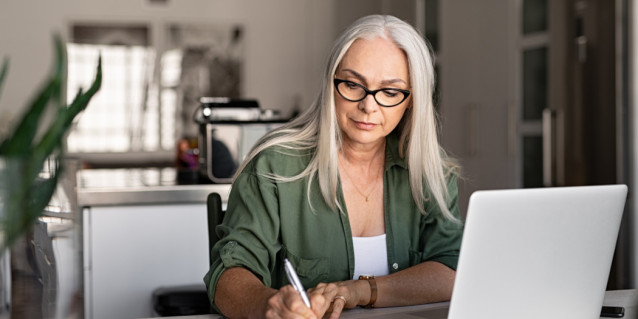 Frau sitzt vor Laptop und schreibt Kündigung