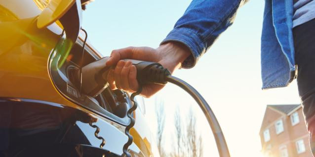 Person lädt Elektroauto auf