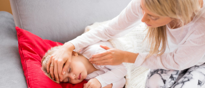 Mutter fühlt ihrem fieberkranken Kind die Stirn Mutter fühlt ihrem fieberkranken Kind die Stirn