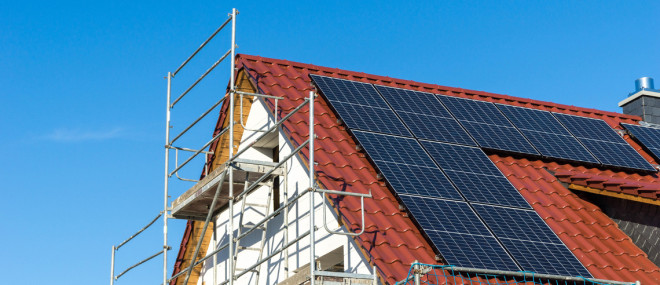 Photovoltaikanlage: Ist eine Baugenehmigung nötig? Am Giebel eines Hauses steht ein Gerüst, auf dem Dach ist eine Photovoltaikanlage befestigt. Photovoltaikanlage: Ist eine Baugenehmigung nötig? Am Giebel eines Hauses steht ein Gerüst, auf dem Dach ist eine Photovoltaikanlage befestigt.