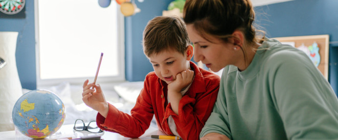 Mutter und Sohn machen in Kinderzimmer Schulaufgaben