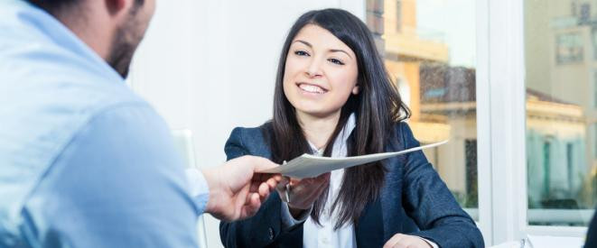 Lächelnde Frau gibt Mann in Büro ein Dokument