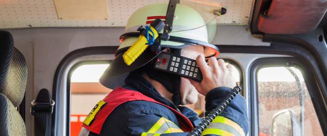 Feuerwehrmann im Feuerwehrwagen am Funkgerät