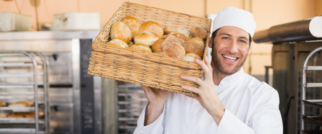Bäcker trägt einen Korb Brötchen auf der Schulter