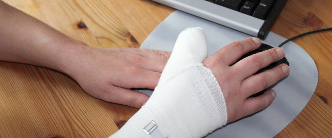 Arbeitsunfall melden: verbundene rechte Hand arbeitet mit der Computer-Maus