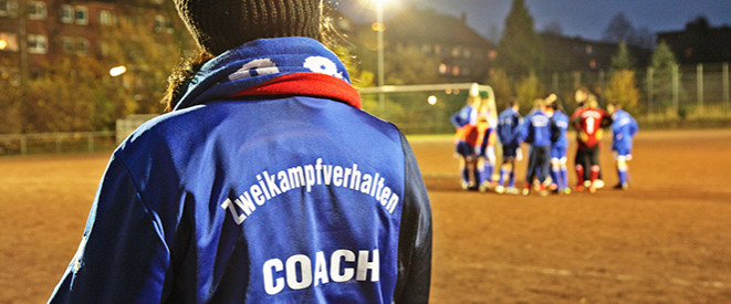 Zweikampfverhalten e.V.: Coach mit blauer Trainingsjacke und dem Schriftzug 
