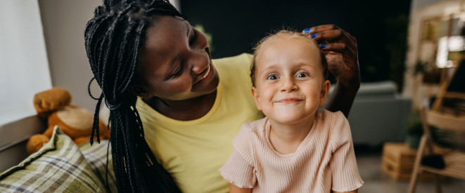 Frau mit Adoptivkind auf dem Schoß