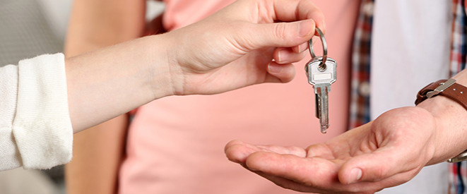 Vermieterbescheinigung: Nahaufnahme einer Hand, die Wohnungsschlüssel in die Hand eines anderen legt