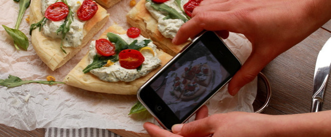 Foodporn: Frau fotografiert mit dem Smartphone ihr Essen 