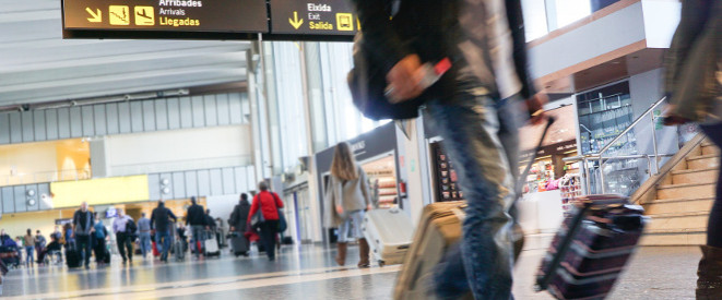 Reisende mit Handgepäck an einem Flughafen