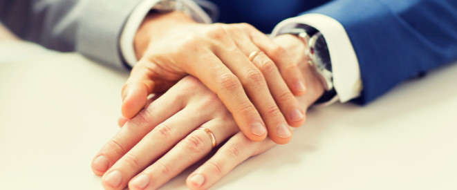 Zwei Männer halten Händchen: Lebenspartnerschaftsgesetz klärt Rechtliches zur Homo-Ehe
