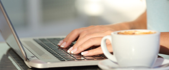 Zwei Frauenhände tippen auf einer Laptoptastatur: Ist Private Internetnutzung am Arbeitsplatz erlaubt oder verboten?