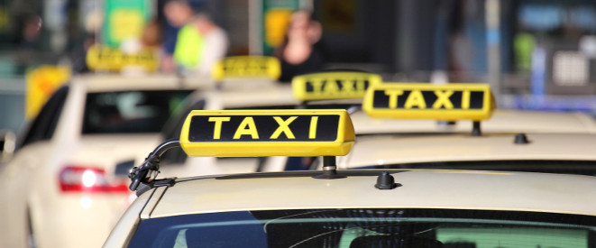 Taxen mit Taxi-Schild auf dem Autodach