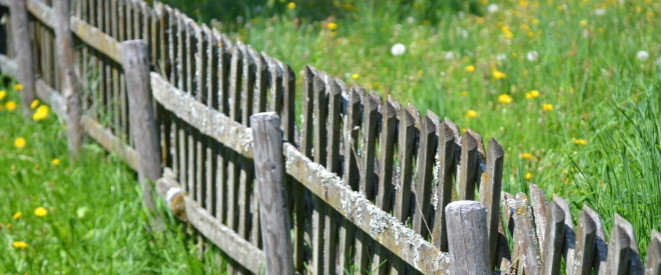 Grundstücksgrenze unklar: Ein Holzzaun auf einer Wiese.