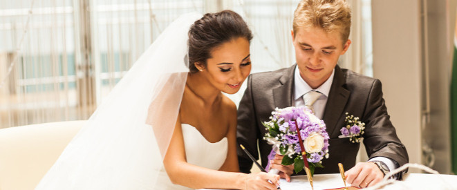 Namensrecht: Ein Brautpaar unterschreibt die Hochzeitsurkunde.