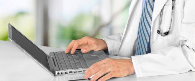BGH-Urteil: Bewertungsportale müssen gründlicher prüfen. Ein Arzt tippt mit seinem Finger auf die Tastatur eines Laptops.