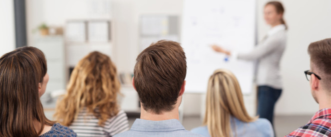 Meister-BAföG: Voraussetzungen und Höhe. Mehrere Personen hören einer Person zu, die vor einem Whiteboard steht.