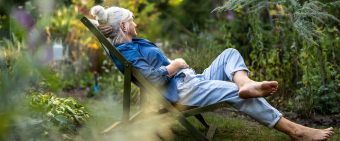 Mature woman relaxing in deckchair in her garden