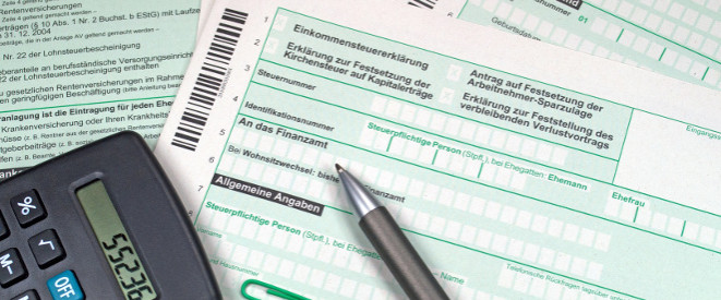 Steuererklärung zu spät abgegeben: Was passiert? Ein Taschenrechner und ein Kugelschreiber liegen auf den Unetrlagen zur Steuererklärung.