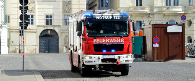 Auf Einsatzfahrt geblitzt: Gelten Sonderrechte? Ein Feuerwehrauto steht in einer Stadt auf Kopfsteinpflaster.